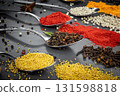 Collection of spices are spread out on a table. The spices include cumin, paprika, and turmeric 131598818