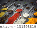 Collection of spices are spread out on a table. The spices include cumin, paprika, and turmeric 131598819