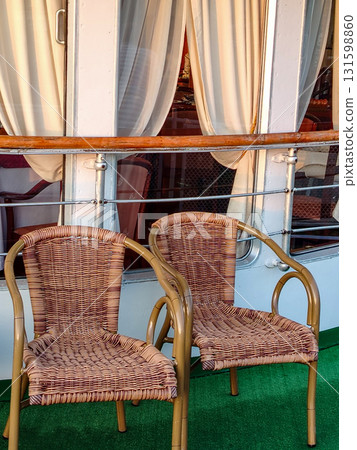 Two wicker chairs on the ship's balcony, close-up, vertical Two wicker chairs on the ship's balcony, close-up, vertical 131598860