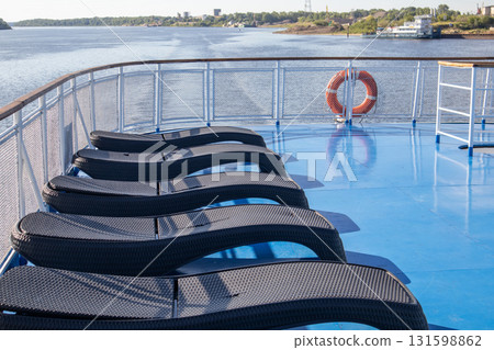 The open deck of a cruise ship with rows of sun loungers The open deck of a cruise ship with rows of sun loungers 131598862