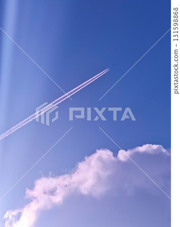 Jet plane with pink contrails in purple sky and clouds, vertical shot Jet plane with pink contrails in purple sky and clouds, vertical shot 131598868