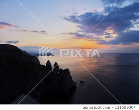 Summer in Muroran, Hokkaido: View of the sun rising over the horizon from near Kameiwa Rock Summer in Muroran, Hokkaido: View of the sun rising over the horizon from near Kameiwa Rock 131599304