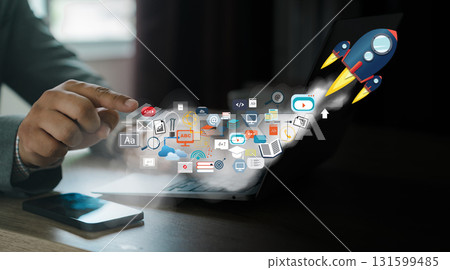 Startup rocket launch, fast growth, digital advertising success. Business hand at a laptop triggers flying icons, representing SEO, PPC, content, email, data analytics. Startup rocket launch, fast growth, digital advertising success. Business hand at a laptop triggers flying icons, representing SEO, PPC, content, email, data analytics. 131599485