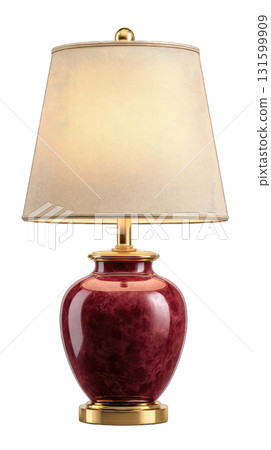 Table lamp with red ceramic base and beige shade glowing warmly 131599909