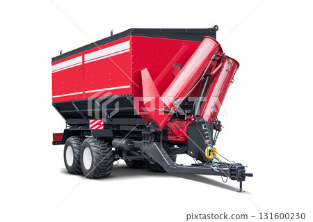 Heavy-duty red agricultural mixer resting on an isolated farm field under clear blue skies 131600230