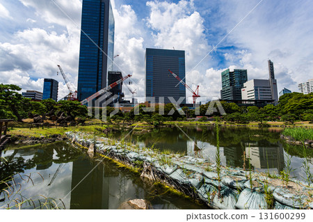 Sandbags in the pond at the former Shiba Rikyu Gardens in Tokyo, with skyscrapers reflected on the water, and a cityscape under construction Sandbags in the pond at the former Shiba Rikyu Gardens in Tokyo, with skyscrapers reflected on the water, and a cityscape under construction 131600299