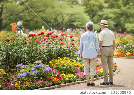 微笑的老年夫婦手牽手在公園散步，享受春天陽光和大自然的寧靜時光 131600970