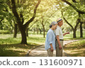 微笑的老年夫婦手牽手在公園散步，享受春天陽光和大自然的寧靜時光 131600971
