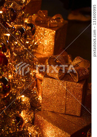 Close-up of the present boxes under the Christmas trees with colorful ornaments. Christmas presents, gifts. Festive decoration. Winter season, winter festive. Xmas celebration. For background use. 131600995