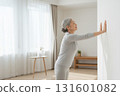 老年婦女在室內伸展：平靜的早晨健康習慣和輕鬆的生活方式 131601082