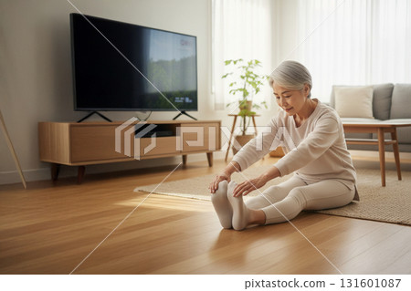 老年婦女在室內伸展：平靜的早晨健康習慣和輕鬆的生活方式 131601087