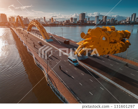 Golden Dragon Bridge over Han River in Da Nang at sunset, Iconic Vietnamese landmark spanning urban waterway with city skyline view 131601297