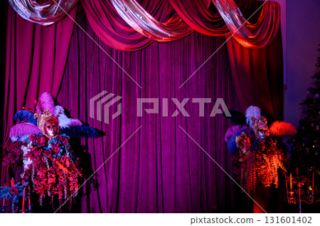 Party decor with masks, and feathers against a backdrop of purple curtains 131601402