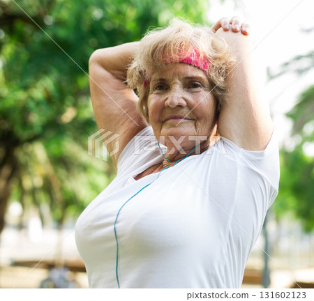 Aged woman warming up in park 131602123
