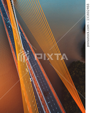 Symmetric modern cable-stayed bridge over rive, Contemporary urban span connecting city across waterway Symmetric modern cable-stayed bridge over rive, Contemporary urban span connecting city across waterway 131602468