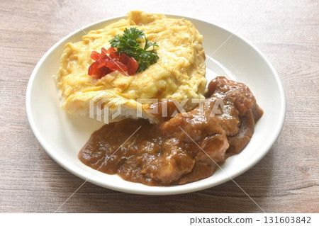 fried creamy egg omelet topping plain rice dressing potato and carrot in Japanese curry on plate  131603842