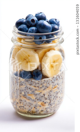 Glass jar filled with overnight oats, almond milk, chia seeds, and topped with blueberries and banana slices - isolated on white background. Minimal aesthetic, healthy breakfast, transparent Glass jar filled with overnight oats, almond milk, chia seeds, and topped with blueberries and banana slices - isolated on white background. Minimal aesthetic, healthy breakfast, transparent 131604059