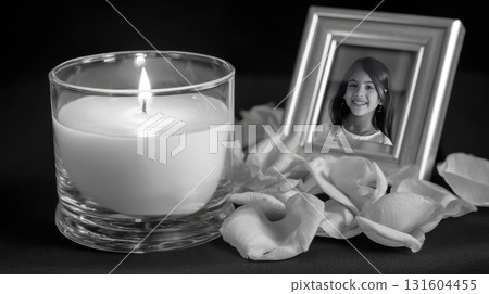 Isolated white scene with soft-lit candle, marigolds, and remembrance photo symbolizing Mexican traditions 131604455