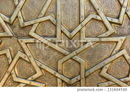 Brass doors adorned with Moroccan patterns, metal filigree, and intricate relief work. Royal Palace, Fez, Morocco Brass doors adorned with Moroccan patterns, metal filigree, and intricate relief work. Royal Palace, Fez, Morocco 131604599