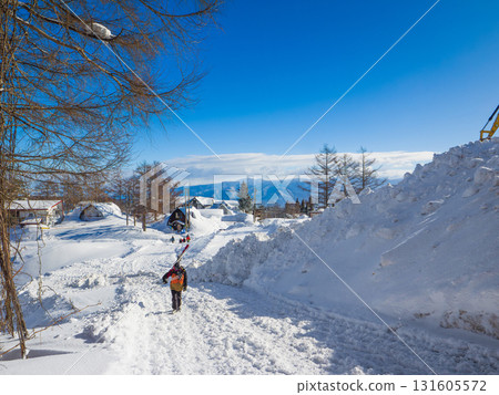 滑雪者在民宿小鎮的積雪道路上滑雪(新潟縣斑尾高原) 滑雪者在民宿小鎮的積雪道路上滑雪(新潟縣斑尾高原) 131605572
