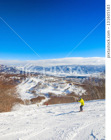 在晴朗的日子裡,滑雪者在滑雪勝地一邊欣賞未經修整的雪道,一邊欣賞壯麗的景色(新潟縣斑尾高原) 在晴朗的日子裡,滑雪者在滑雪勝地一邊欣賞未經修整的雪道,一邊欣賞壯麗的景色(新潟縣斑尾高原) 131605583