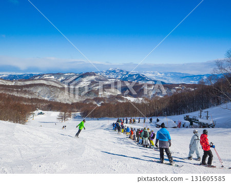 A ski resort on a clear day with a large crowd waiting for the lift to the summit and a spectacular view of the snow-capped mountains (Madarao Kogen, Niigata Prefecture) A ski resort on a clear day with a large crowd waiting for the lift to the summit and a spectacular view of the snow-capped mountains (Madarao Kogen, Niigata Prefecture) 131605585