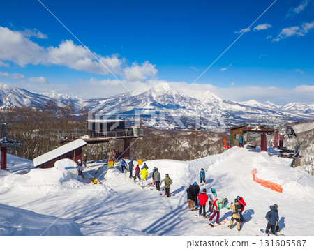A line of people waiting for the lift at a ski resort on a clear day, with the magnificent view of Mt. Myoko (Madarao Kogen, Nagano Prefecture) A line of people waiting for the lift at a ski resort on a clear day, with the magnificent view of Mt. Myoko (Madarao Kogen, Nagano Prefecture) 131605587