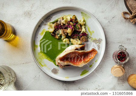 Grilled sea bass with vegetables and green sauce Grilled sea bass with vegetables and green sauce 131605866