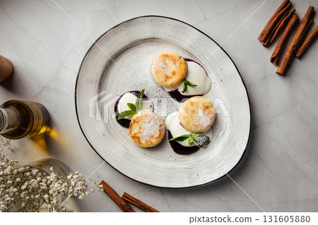 Three cottage cheese pancakes with sour cream and berries 131605880