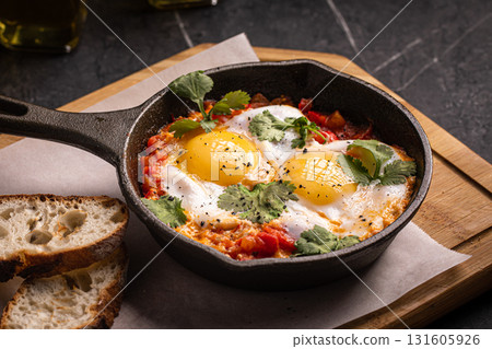 Shakshuka with poached eggs and vegetables 131605926