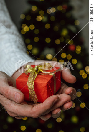 gift exchange moment during holiday celebration with festive background. closeup. 131606010