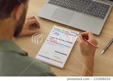 Rear View of Man Writing To Do List with Pencil Rear View of Man Writing To Do List with Pencil 131606030
