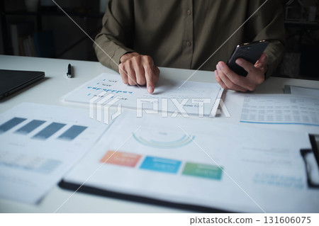 Businessman reading report in office desk analyze data for plan project 131606075