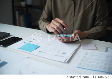 Businessman reading report in office desk analyze data for plan project 131606076