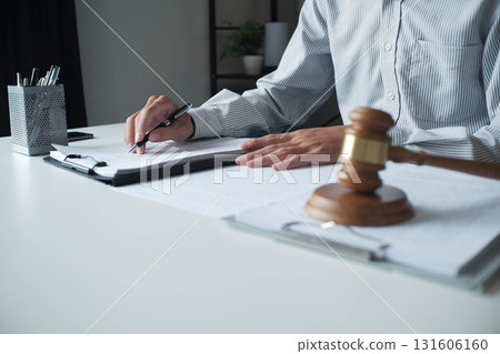 Legal justice man working on desk reading supportive documents to determine the case 131606160
