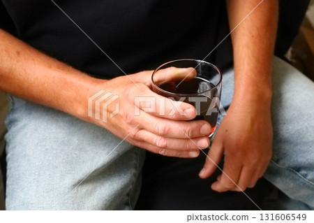 Man holding glass of dark drink Man holding glass of dark drink 131606549