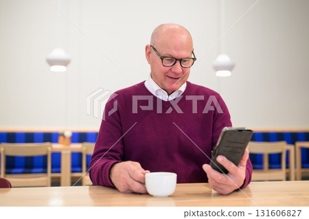 Portrait of senior man using mobile phone while having coffee in cafe Portrait of senior man using mobile phone while having coffee in cafe 131606827
