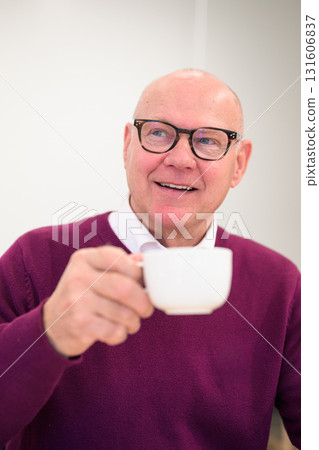 Portrait of a senior man with cup of coffee in his hand thinking 131606837