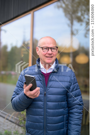 Portrait of a senior Scandinavian man using a mobile phone in the city 131606860