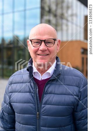 Portrait of a smiling senior man with glasses and a blue jacket 131606873
