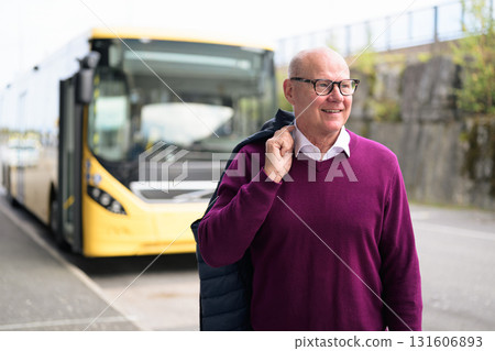 Portrait of a smiling senior Scandinavian man standing in front of a bus Portrait of a smiling senior Scandinavian man standing in front of a bus 131606893