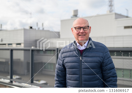Portrait of a happy mature bald man with eyeglasses outdoors Portrait of a happy mature bald man with eyeglasses outdoors 131606917