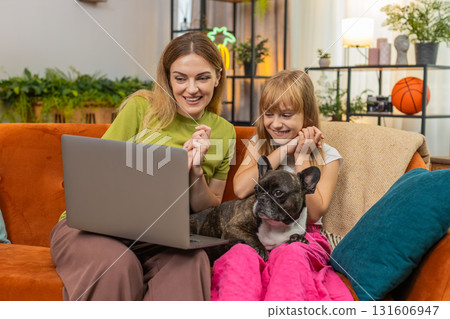 Mother daughter dog win game on laptop get positive test result celebrate good news smile together Mother daughter dog win game on laptop get positive test result celebrate good news smile together 131606947