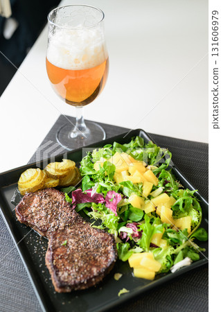 Healthy steak and salad meal on table at home served with beer 131606979