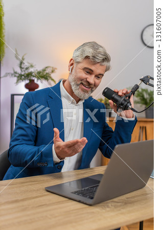 Businessman hosts podcast speaking into studio mic using lively gestures delivering expert tips Businessman hosts podcast speaking into studio mic using lively gestures delivering expert tips 131607005