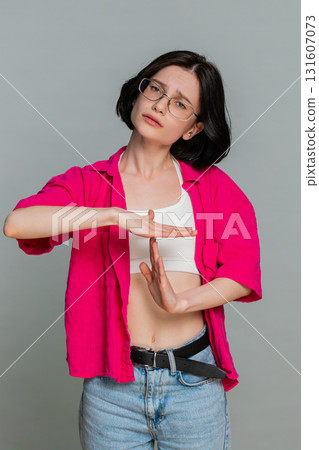 Young woman showing timeout gesture with hands seriously asking for pause break stop communication 131607073