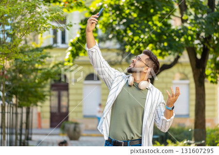 Frustrated young man trying to catch signal on smartphone for better connection in city street Frustrated young man trying to catch signal on smartphone for better connection in city street 131607295
