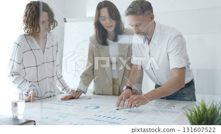 Professional team reviewing financial data, collaborating on working documents, demonstrating team achievements and positive dynamics in the workplace. Business people concept Professional team reviewing financial data, collaborating on working documents, demonstrating team achievements and positive dynamics in the workplace. Business people concept 131607522