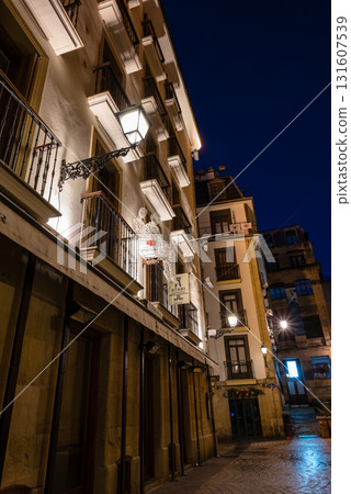 The old town of San Sebastian, Spain, before dawn: deserted cobblestone streets, streetlights and historic buildings The old town of San Sebastian, Spain, before dawn: deserted cobblestone streets, streetlights and historic buildings 131607539