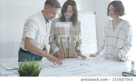 Professional team reviewing financial data, collaborating on working documents, demonstrating team achievements and positive dynamics in the workplace. Business people concept Professional team reviewing financial data, collaborating on working documents, demonstrating team achievements and positive dynamics in the workplace. Business people concept 131607563